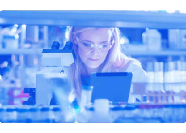 Female doctor looking over tablet and microscope